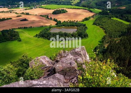 Teich in einer wunderschönen Landschaft mit Wäldern, Wiesen und Feldern unter Semnicka skala im Landschaftsschutzgebiet Slavkovsky les bei Karlsbad, Stockfoto