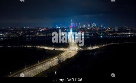 Eine hochfliegende Drohne fängt Warschaus pulsierende Skyline ein: Die Świętokrzyski-Brücke, leuchtende Türme und endlose Lichter der Stadt. Stockfoto