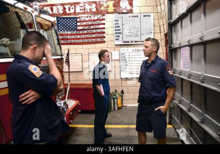 Mitglieder des Ladder 4 Engine 54 Stationshauses auf der achten Ave. Sprechen in ihrem Stationshaus in New York, NY, Dienstag, 2. September 2002. L bis R sind: John Heaney, Bill Sherwin und Patrick Moore. Die Feuerwehr verlor alle 15 Männer ihrer Tagestour am 11. September. An der Mauer dahinter befindet sich das beschädigte Schild von Leiter 4, das aus den Trümmern geborgen wurde. Darunter eine Fahne mit den Namen der 15 Verstorbenen und die Arbeitsdetailtafel von diesem Tag mit den Namen der Dienstleistenden, die noch unberührt bleiben. (Bild: Washington Times/ZUMAPRESS.com) Stockfoto