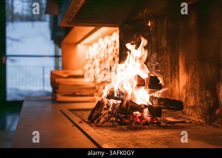 Moderner Kamin mit schneebedecktem Alpenblick in den italienischen Alpen Stockfoto
