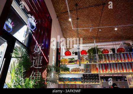 Lemberg, Ukraine - 06. April 2025: Modernes Café mit asiatischen Elementen, Neonlichter, rote Dekorationen und Pflanzen. Stockfoto