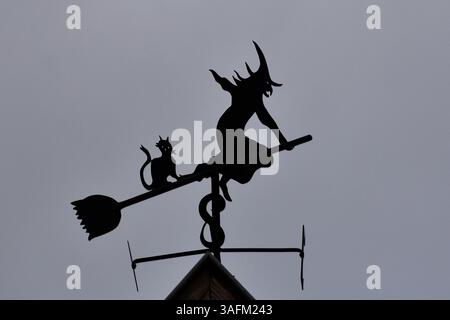Wetterfahne in Form einer Hexe, die auf einem Besen auf dem Dach eines Hauses in Bergheim im Elsass fliegt Stockfoto