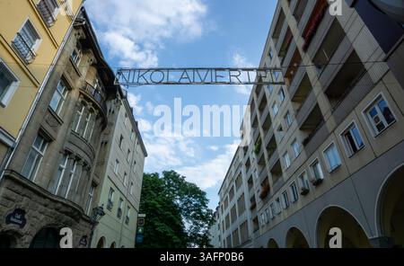 Das Schild „Nikolaiviertel“ befindet sich über einer Straße im historischen Viertel Berlins, in der die Gebäude der Umgebung moderne und historische Architektur zeigen. Stockfoto