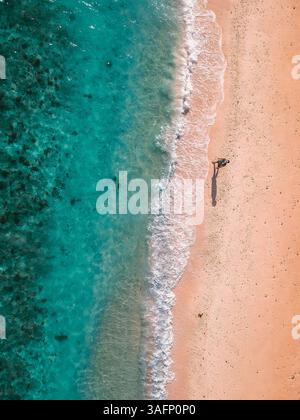 Aus der Vogelperspektive auf einen ruhigen Strand auf den Philippinen mit türkisfarbenem Wasser und sanften Wellen, gefangen von einer Drohne Stockfoto