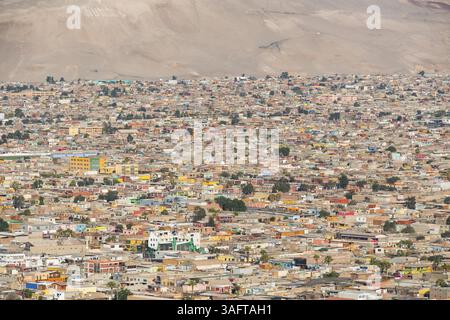 Blick vom Morro de Arica Aussichtsberg auf die kleinen bunten Häuser im armen Viertel, mit der Wüste dahinter, Stadt Arica, Chile, Süden Stockfoto