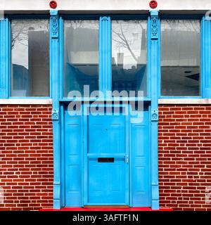 Hellblaue Tür- und Fensterrahmen stehen in einem markanten Chicago-Straßenbild in einem scharfen Kontrast zu roten Ziegelsteinen und weißen Zierleisten Stockfoto