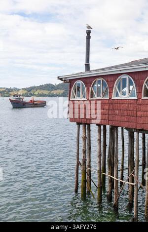 Die farbenfrohen Palafito-Stelzenhäuser auf Chiloé Island zeigen den Einfallsreichtum der Chilote, der indigene und europäische Stile vereint. Über Wasser gebaut, verkörpern sie mar Stockfoto