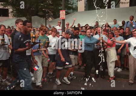 Diane Williams, Ehefrau von Washington Mayor Anthony Williams und Ratsmitglied Jack Evans, Ward 2, öffnen eine Flasche Champagner, um das 26. Jährliche Bastille Day Race and Celebration vor dem Les Halles Restaurant in Washington, DC zu starten, wo die teilnehmenden Kellner um Tickets für die hin- und Rückfahrt nach Paris konkurrieren, indem sie 12 Blocks und zurück auf der Pennsylvania Avenue eine Flasche Champagner und zwei Gläser auf einem Tablett ausbalancieren 2000. (Bild: Washington Times/ZUMAPRESS.com) Stockfoto