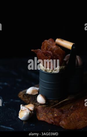 Fleischträger, Hühnerjacken, in einer Eisenkiste vor dunklem Hintergrund. Nahaufnahme Stockfoto