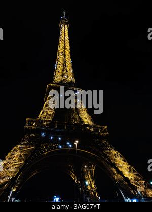 Paris, Frankreich - 28. März 2025: Der Eiffelturm in Paris, Frankreich, wird nachts hell beleuchtet und zeigt atemberaubende Architektur Stockfoto
