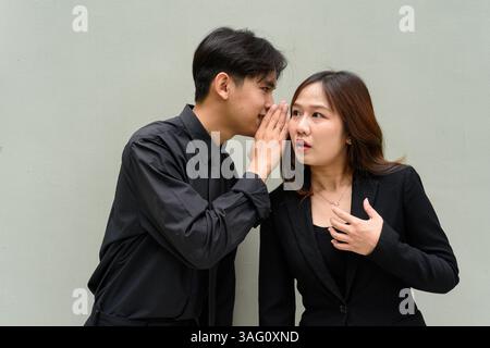 Porträt eines jungen asiatischen Paares, das Geschäftsuniform vor klarem Hintergrund trägt Stockfoto
