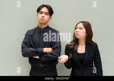 Porträt eines jungen asiatischen Paares, das Geschäftsuniform vor klarem Hintergrund trägt Stockfoto