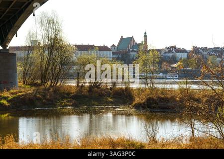 Warszawa, rekonstruierte Altstadt, Königliche Burg von der anderen Seite der Weichsel durch natürliche grüne Flussufer gesehen. Sonniger Abend unter der Brücke. Stockfoto