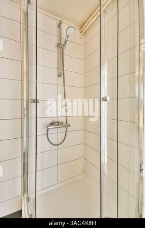 Eine moderne Duschkabine mit Glastüren, eleganten Armaturen und klaren Linien in einem hellen und minimalistischen Badezimmer. Stockfoto