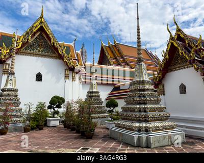 Dieses atemberaubende Bild am Tag zeigt die komplizierten Chedis und die traditionelle Tempelarchitektur im Wat Phra, Bangkok, Thailand. Die Chedis, geschmückt mit Stockfoto