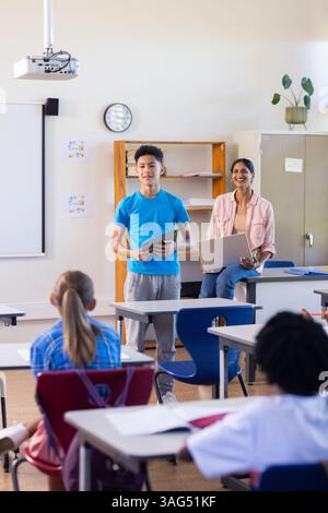 Präsentation des Projekts in der Schule, Schüler stehend, während indische Lehrerin und Klassenkameraden zusehen Stockfoto