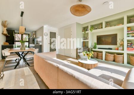 Ein geräumiges und einladendes modernes Wohnzimmer, das nahtlos mit einem Essbereich verbunden ist, mit eleganten Möbeln und Tageslicht. Stockfoto