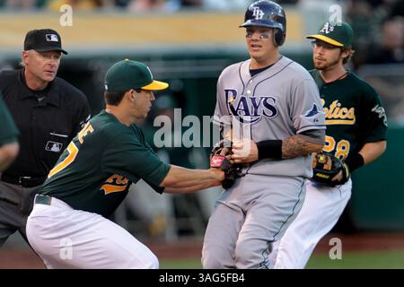 31. Juli 2012 – Oakland, CA, USA – Oakland Athletics Pitcher Tommy Milone (57) markiert Jose Lobaton der Tampa Bay Rays in der Mitte, nachdem er am Dienstag, den 31. Juli 2012, im dritten Inning im O.Co Coliseum in Oakland, Kalifornien, zwischen der dritten Basis und dem Heimstadion in der Mitte des Tampa Bay Rays verwickelt wurde. (Bild: © Ray Chavez/Oakland Tribune/MCT/ZUMAPRESS.com) Stockfoto
