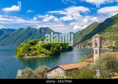 Blick auf den charakteristischen Glockenturm der Kirche Santa Maria Maddalena mit Isola Comacina im Hintergrund. Ossuccio, Tremezzina, Comer See. Stockfoto