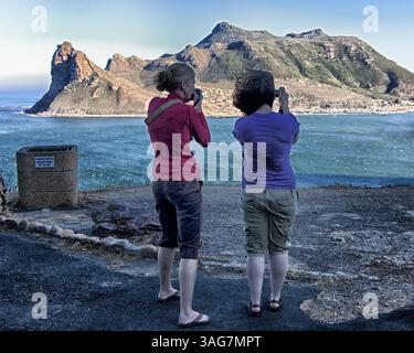 18. März 2011 - Hout Bay, Westkap, Südafrika - Touristen fotografieren Hout Bay vom Chapmanâ Peak Drive. Der Sentinel (links), ein Wahrzeichen an der westlichen Spitze, bewacht den Eingang zur Bucht und zum Hafen an der Atlantikküste der südlichen Kaphalbinsel Africaâ, 20 km südlich von Kapstadt. (Bild: © Arnold Drapkin/ZUMAPRESS.com) Stockfoto