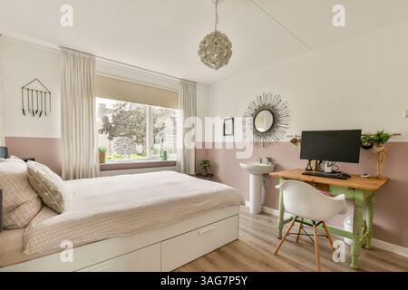 Ein wunderschön gestaltetes, modernes Schlafzimmer mit stilvoller Einrichtung, Arbeitsplatz und Tageslicht durch große Fenster. Stockfoto