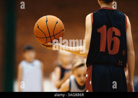 Junger Basketballspieler mit Ball bei der Trainingsübung. Jugendbasketballspieler in der Übungseinheit Stockfoto