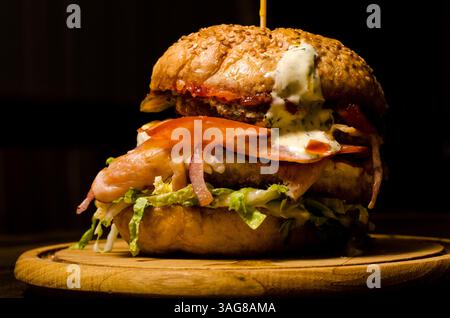 Speck-Burger mit Rindfleisch auf Holztisch Stockfoto