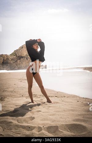 Das wunderschöne venezolanische, blonde Bikinimodell genießt die Schönheit des Alboran Sea und genießt im Urlaub ein herrliches Strandglück. Stockfoto