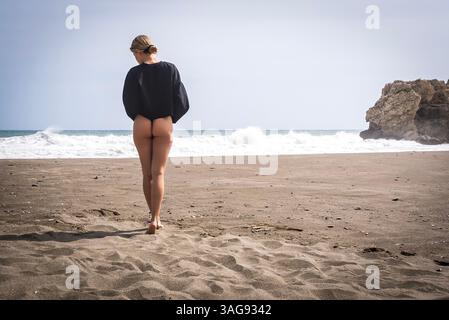 Das wunderschöne venezolanische, blonde Bikinimodell genießt die Schönheit des Alboran Sea und genießt im Urlaub ein herrliches Strandglück. Stockfoto