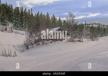 Eine kleine Hütte am Hang eines schneebedeckten Berges Stockfoto