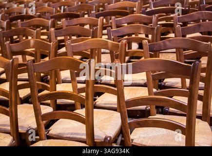 Reihen von Holzstühlen in der Kirche. Stockfoto