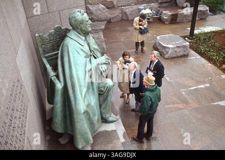 23. April 1997 – Washington, DC, USA – Eine Gruppe von Menschen studiert die Statue des Präsidenten Franklin D. Roosevelt am 23. April 1997 in Washington, DC. Die Statue zeigt einen verhüllten Roosevelt, der von Polio im Rollstuhl verkrüppelt wurde. (Bild: © Richard Ellis/ZUMAPRESS.com) Stockfoto