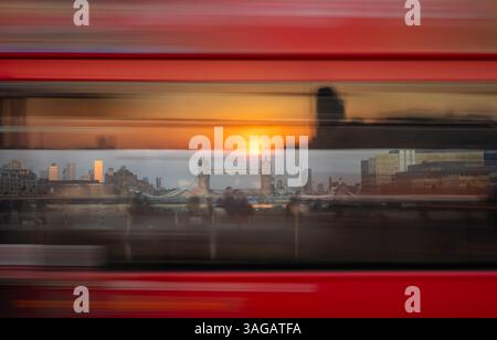 London, Großbritannien: Blick auf die Tower Bridge und die Wolkenkratzer der Londoner Docklands durch die Fenster eines fahrenden Busses mit Sonnenaufgang Stockfoto