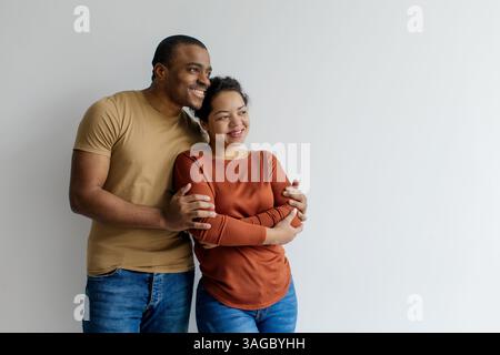 Glückliches, junges schwarzes Paar, das sich umschließt und den Kopierraum ansieht Stockfoto