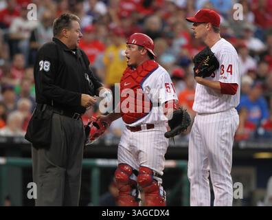 22. Mai 2012 - Philadelphia, PA, USA - Philadelphia Phillies Catcher Carlos Ruiz, Mitte, streitet seinen Fall mit dem Heimplattenteam Gary Cederstrom, nachdem er im dritten Inning eines MLB-Spiels gegen die Washington Nationals im Citizens Bank Park in Philadelphia, Pennsylvania, am Dienstag, den 22. Mai 2012 aus dem Spiel geworfen wurde. Phillies Pitcher Roy Halladay schaut zu. (Bild: © Michael Bryant/Philadelphia Inquirer/MCT/ZUMAPRESS.com) Stockfoto