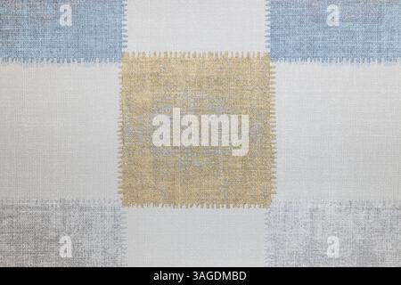 Strukturiertes Stoffgewebe mit genähtem Patchwork-Design in sanften neutralen Farben Stockfoto