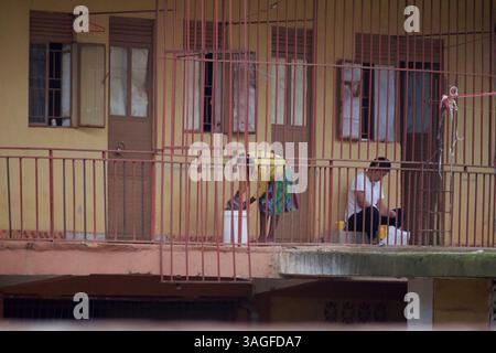 Frauen waschen sich auf einem Balkon in Afrika hinter Gittern eines Hauses in Afrika Stockfoto