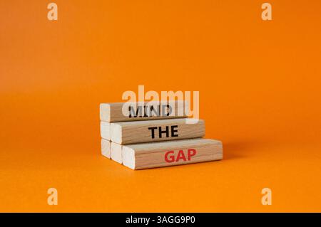 Beachten Sie das Lückensymbol. Konzeptworte beachten Sie die Lücke auf Holzblöcken. Wunderschöner orangefarbener Hintergrund. Und denken Sie an das GAP-Konzept. Kopierbereich. Stockfoto