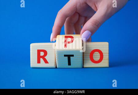 RPO vs. RTO-Symbol. Geschäftsmann-Hand dreht Holzwürfel und ändert das Wort RTO in RPO. Wunderschöner blauer Hintergrund. Geschäftskonzept. Kopierbereich Stockfoto