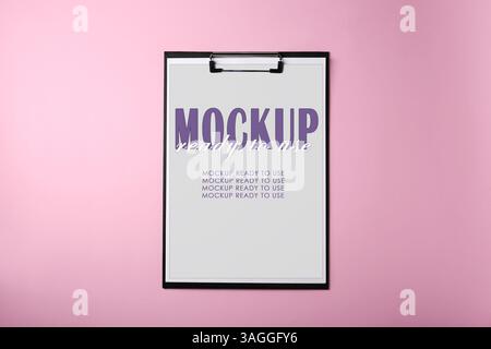 Zwischenablage mit Blatt Papier auf rosafarbenem Hintergrund, Draufsicht. Modell Einsatzbereit Stockfoto