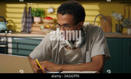 Konzentrierter Mann Afroamerikaner Guy Business männlicher Freelancer Schüler High School Gene z zu Hause Küche mit Laptop Online-Klasse Lernen fern Stockfoto