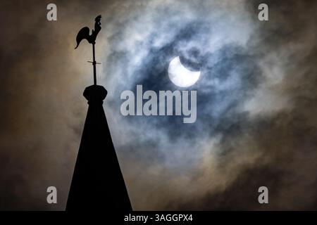 Das Bild zeigt die partielle Sonnenfinsternis in Ely, Cambridgeshire über dem Turm der St. Mary’s Church am Samstagmorgen. Die partielle Sonnenfinsternis wird es Stockfoto