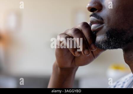 Ein nachdenklicher Mann, der das Kinn auf der Hand ruht und drinnen in ungezwungener Umgebung nachdenkt. Nachdenklich, Reflexion, Nachdenken, Denken, Entspannung, männlich Stockfoto