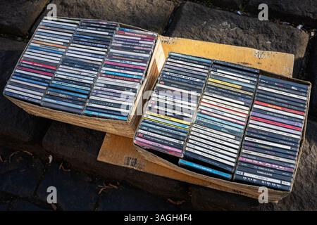 Lviv, Ukraine - 07. April 2025: Ein großes Sortiment an CD-CDs in Kartons, die ordentlich in offenen Holzkisten angeordnet sind. Stockfoto