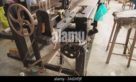 Antiker Fußstuhl für traditionelles Weben mit Holzrahmen und Pedalen. Stockfoto