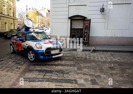 Lviv, Ukraine - 07. April 2025: Ein Mini Cooper-Auto mit einem Red Bull-Design, das auf einer kopfsteingepflasterten Straße parkt. Stockfoto