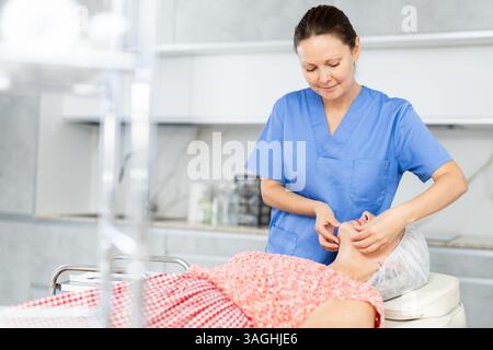 Erfahrener Arzt, der eine Gesichtsmassage an einen Reifen Patienten durchführt Stockfoto