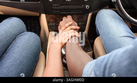 Hände von afroamerikanischem Mann und Frau, die im Auto sitzen Stockfoto