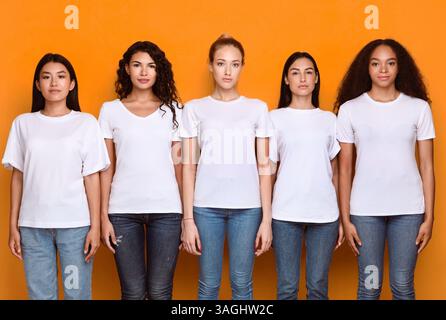 Fünf Ernsthafte Multiethnische Frauen Stehen Zusammen Über Gelbem Hintergrund Stockfoto