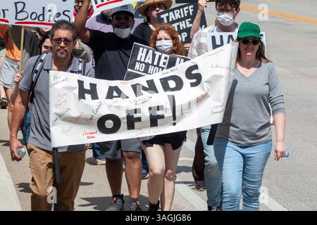 Atlanta, GA / USA - 5. April 2025: Menschen tragen ein Banner mit der Aufschrift „Hands Off“ beim protestmarsch am 5. April 2025 in Atlanta, GA. Stockfoto